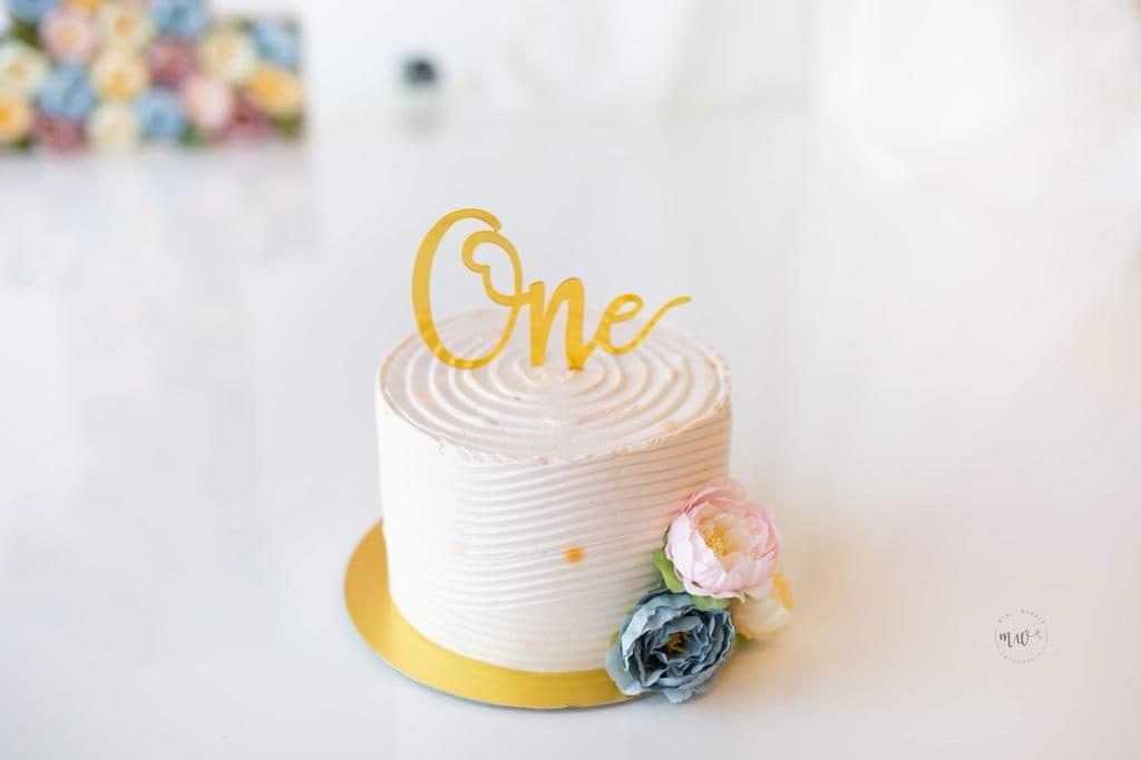 Tarta de buttercream blanco texturizado con flores para primer cumpleaños